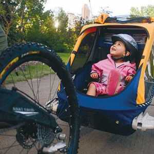 O remorcă pentru biciclete pentru un copil este un asistent fiabil atunci când călătorește cu copii